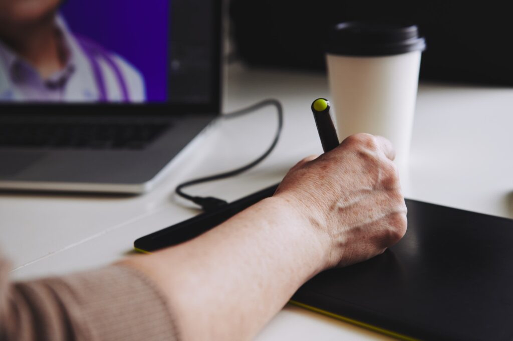 Woman designer working at a laptop with a graphics tablet